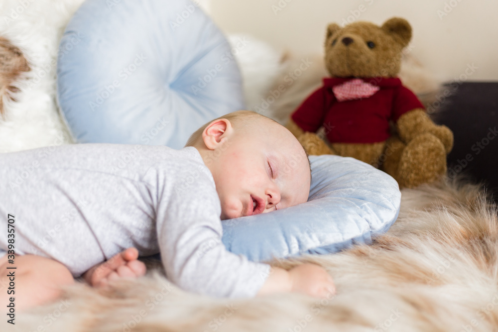 Little baby boy sleeping on a sofa on artificial fur, among toys - teddy bears Little baby boy sleeping on a sofa on artificial fur, among toys - teddy bears