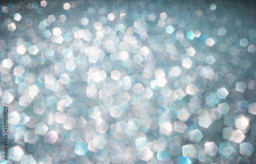 Defocused abstract colorful twinkle light background. Glittery bright shimmering background use as a design backdrop.