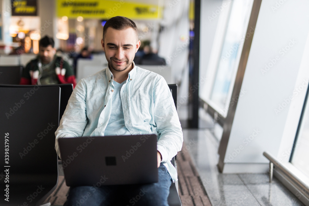 Young handsome man working on a laptop in airport Young handsome man working on a laptop in airport