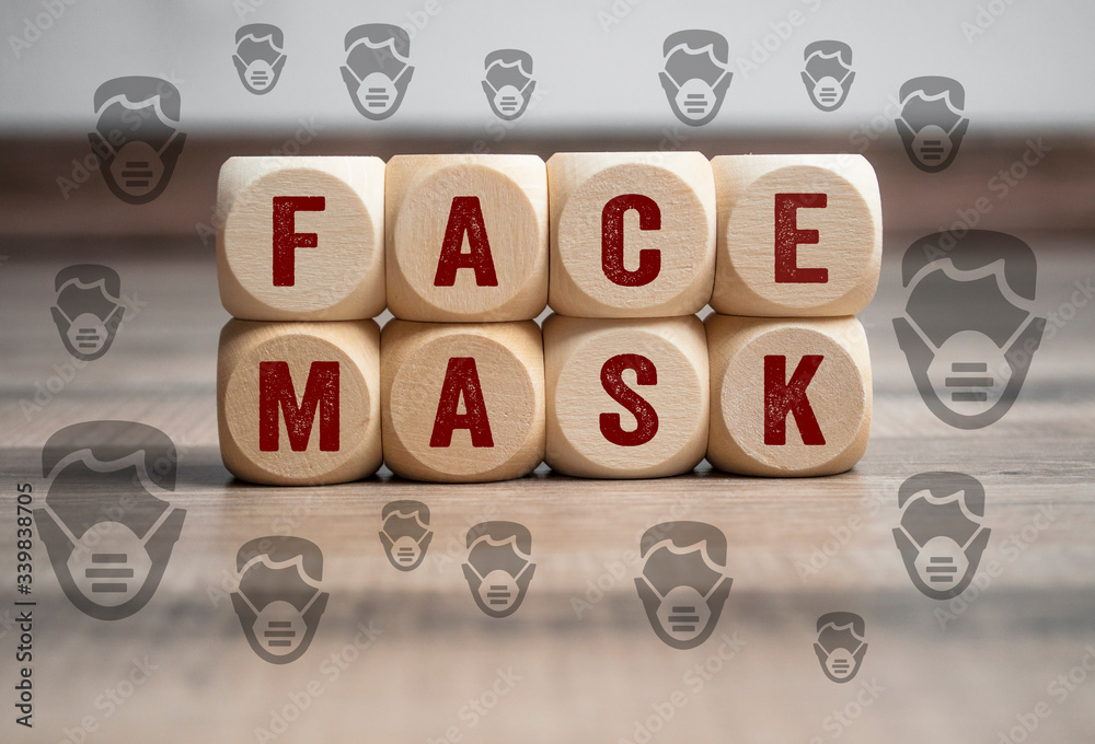 Cubes and dice with corona virus and face mask icons on wooden background Cubes and dice with corona virus and face mask icons on wooden background