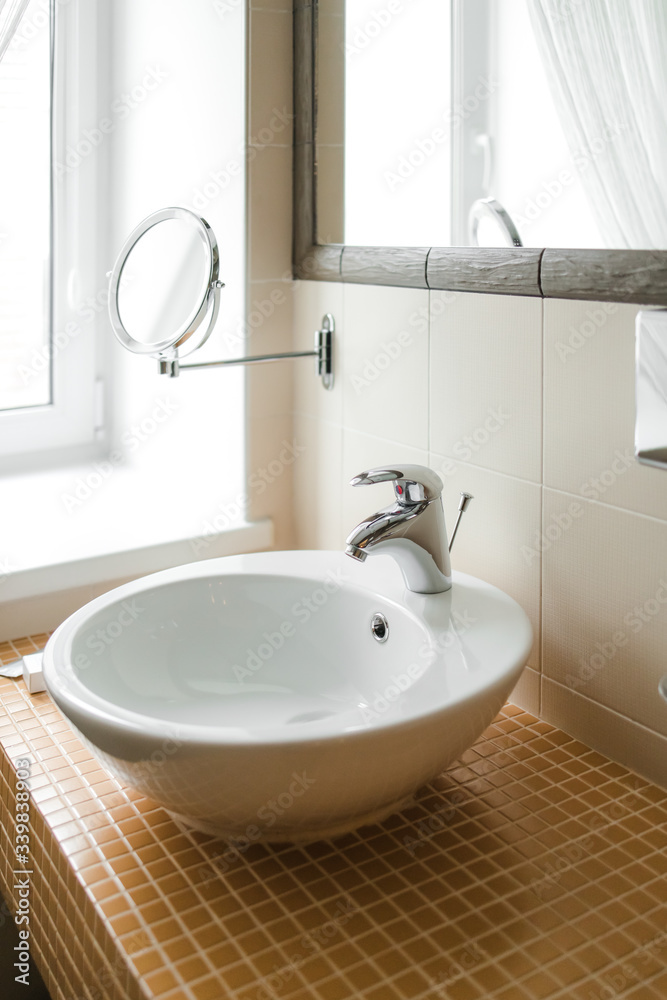 oval white sink in the bathroom on small red tiles in the form of squares oval white sink in the bathroom on small red tiles in the form of squares