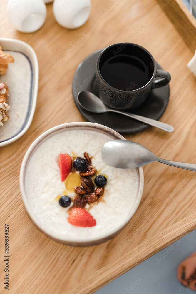 porridge and granola with nuts and berries in a plate on a wooden table porridge and granola with nuts and berries in a plate on a wooden table