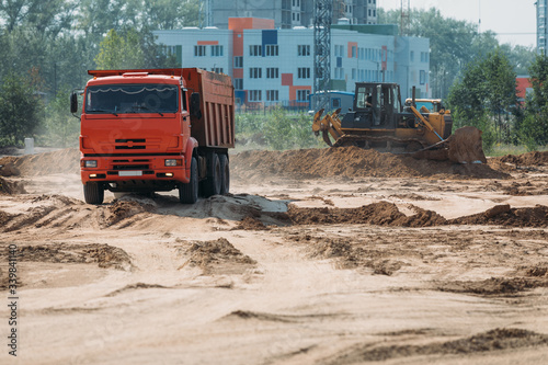 orange dump truck truck at a construction site transports sand