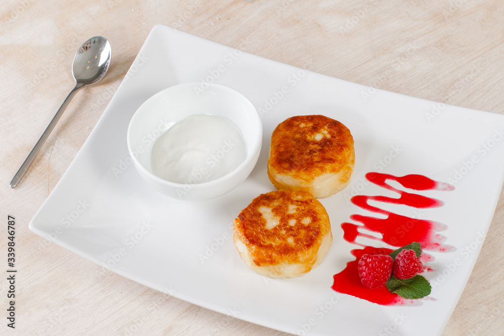 Russian cheese cakes with sour cream and raspberries