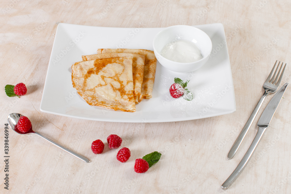 Pancakes with sour cream and raspberries