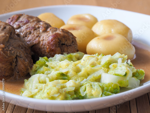 Silesian dumplings with pork roulade and cabbage in roast sauce