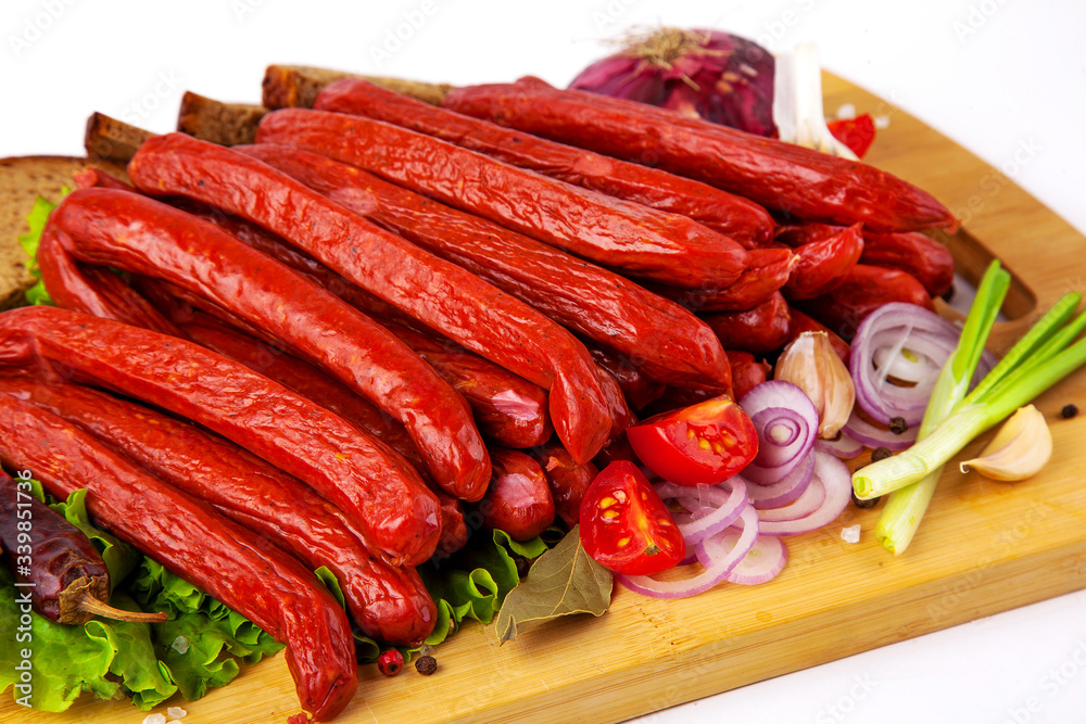 sausage on a cutting board with herbs and vegetables white background
sausage on a cutting board with herbs and vegetables white background