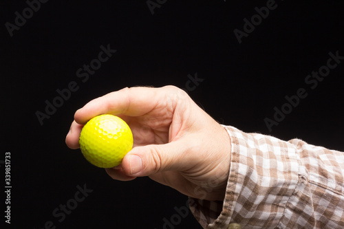 Golf ball in the hand of an adult person © Jorge