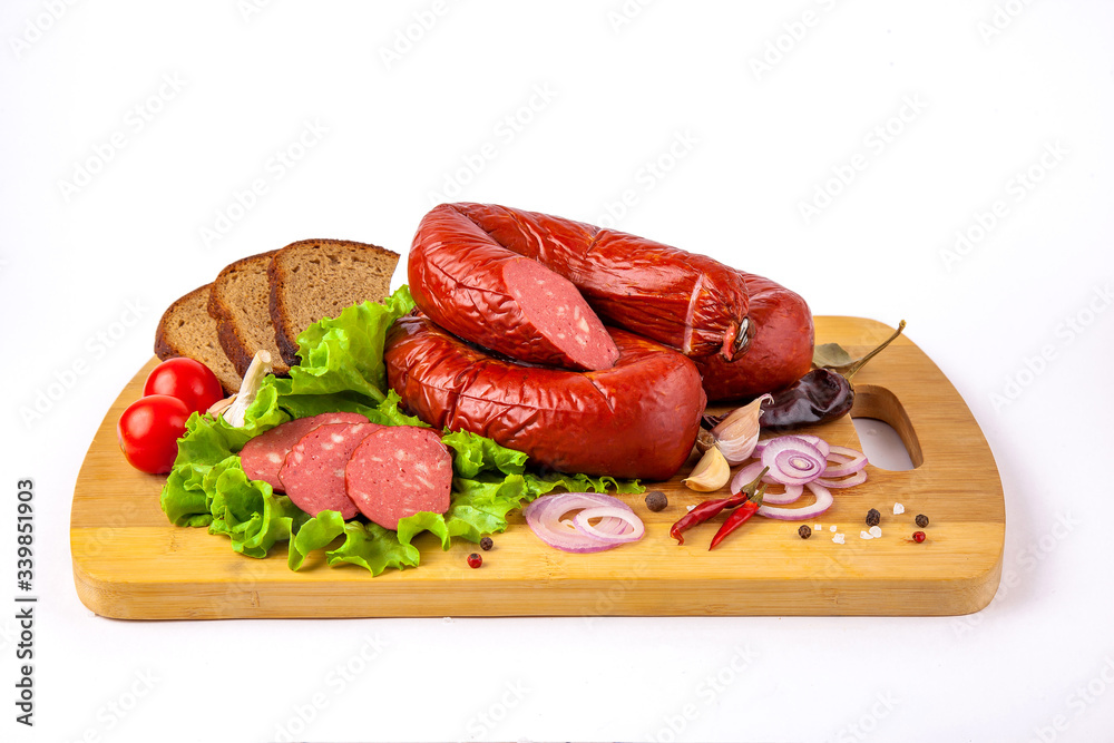 sausage on a cutting board with herbs and vegetables white background
sausage on a cutting board with herbs and vegetables white background