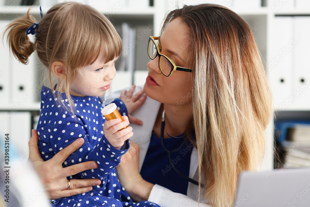 A small child is afraid in the hospital room. The doctor holds his hands and soothes the portrait. A small child is afraid in the hospital room. The doctor holds his hands and soothes the portrait.