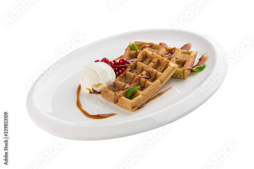 Belgian waffles with ice cream, caramel sauce and red currant isolated on white background