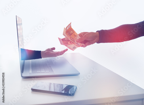 Online transaction. An arm comes out of a laptop to collect money from a customer or taxpayer. It can also represent a person who is being online extorted.