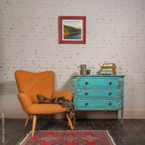 Carta da parati Stile Shabby Chic - Carta da parati Bright orange retro armchair with plaid against white brick wall with shabby chic vintage turquoise cabinet in living room and hanged painting, with clipping path for the painting