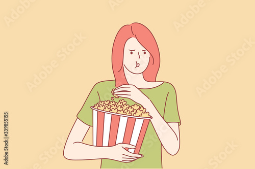Watching movie at cinema concept. Young captivated girl or woman teenager with big portion of popcorn watching films or series at movie theater cinema home. Leisure time illustration in cartoon style.