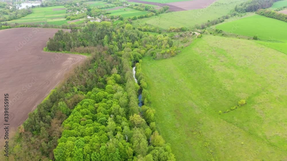 Aerial drone view of small river, fields and forest. Warm spring colors. Green trees and grass. Beautiful landscape of Ukraine. Aerial drone view of small river, fields and forest. Warm spring colors. Green trees and grass. Beautiful landscape of Ukraine.