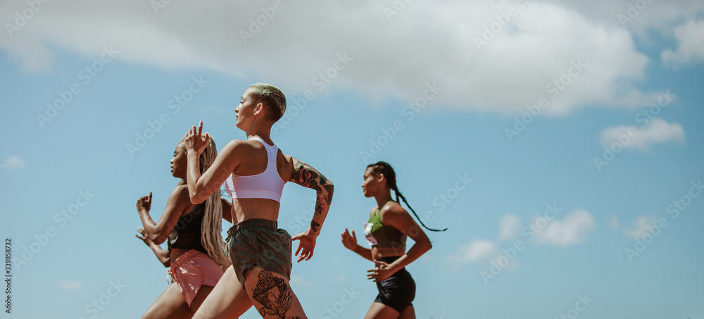 Naklejka premium Female runners competing in a track event