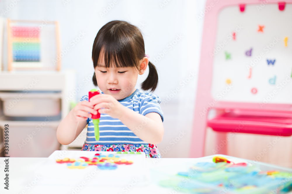 toddler girl playing creative shape blocks at home against white background toddler girl playing creative shape blocks at home against white background