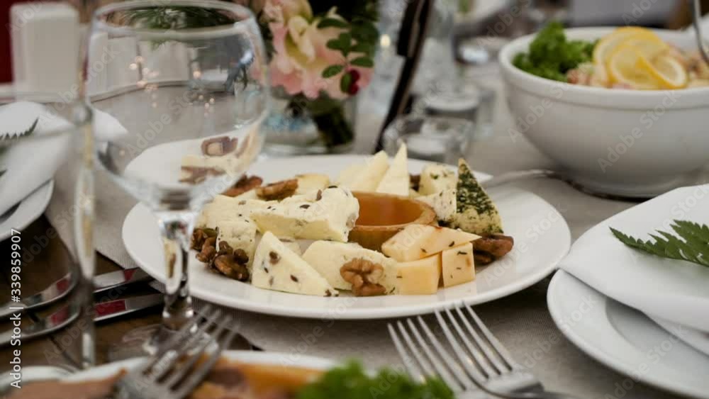 Close-up of Cheese plate with honey at the festive table. Catering and guest services. Dinner in a big company or event.
Close-up of Cheese plate with honey at the festive table. Catering and guest services. Dinner in a big company or event.