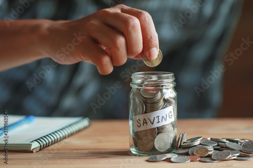 A man putting coin in the glass.concept saving money for finance accounting