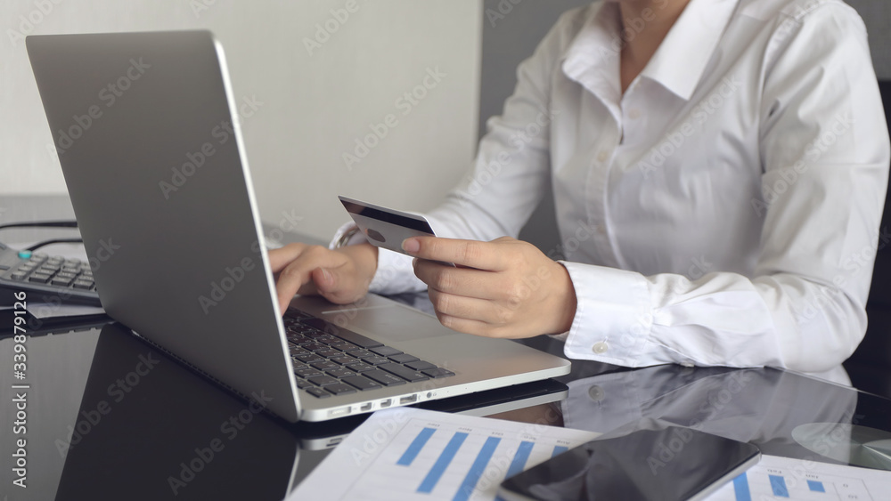 Hands holding credit card and using laptop. Online shopping