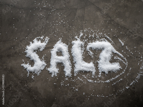 Fotografi German word SALZ (SALT in English) written in salt grains spread on a kitchen ta