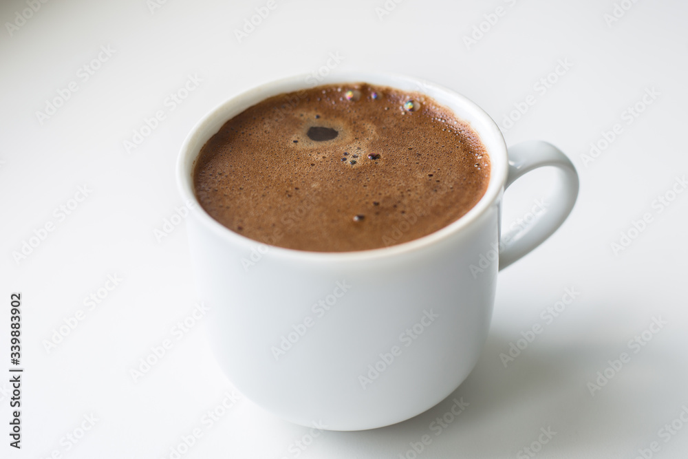 white mug with freshly brewed coffee on a light background, side view white mug with freshly brewed coffee on a light background, side view