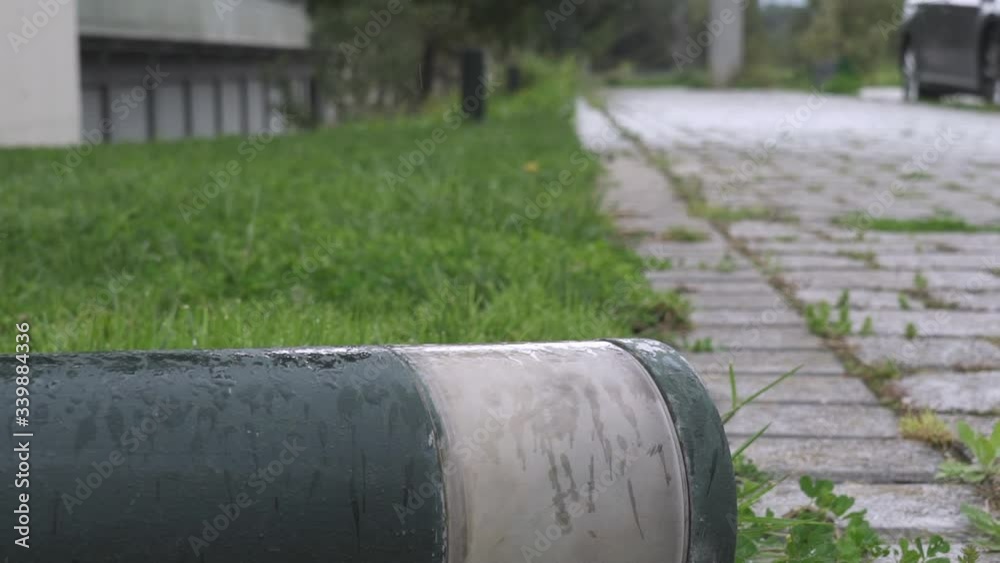 Close shot of broken cement light pole, with rain in the background Close shot of broken cement light pole, with rain in the background