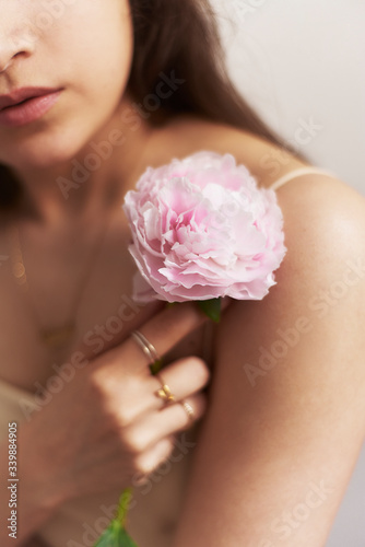 A girl holding a flower in her hand and her chest.