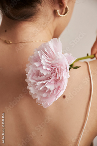 The back of a person with flowers and jewelry