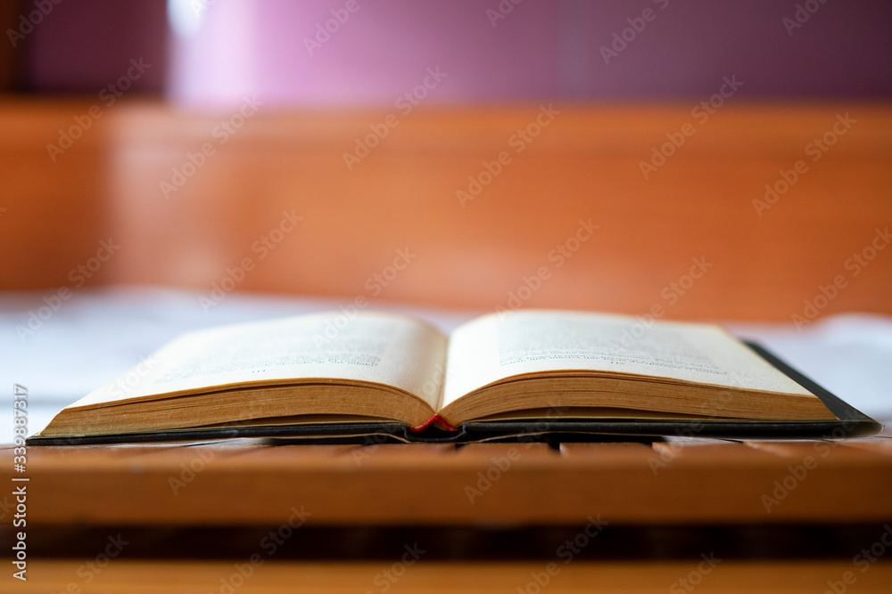 Open book on a white bed. Open book on a white bed.
