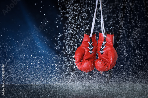 Red boxing gloves on a water drops background. Sport lifestyle. Motivation. Goal achievement. Protect yourself