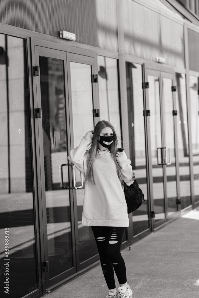 Pretty young woman wearing a protective medical face mask.