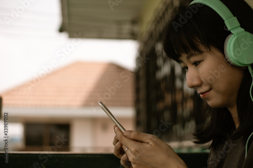 Asian woman wearing headpho...