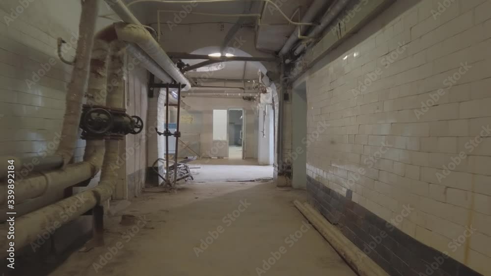 The camera moves along the basement corridor , along the walls are pipes and communications The camera moves along the basement corridor , along the walls are pipes and communications
