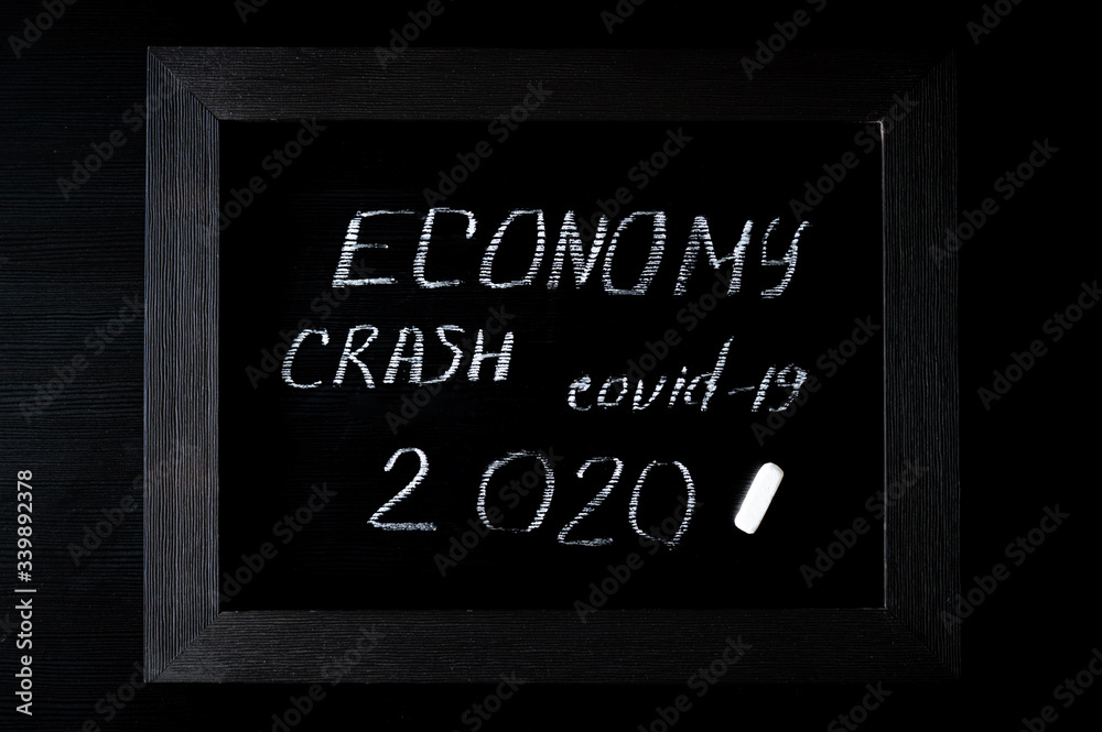 2020 World Economic Crisis caused by the Coronavirus. Covid-19, Recession and economic slowdown, written in chalk on a black background
