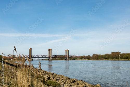  A beautiful red old bridge  river Old Maas and ship with containers in Spijkenisse in Holland