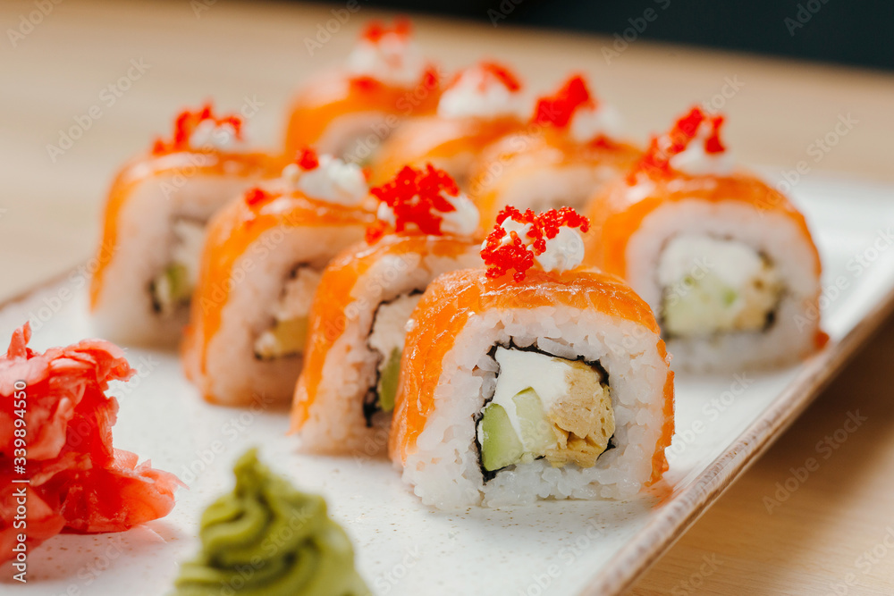 Japanese sushi roll set on delivery in quarantine. Red dragon. Rice, nori, tempura shrimp, tabasco sauce, cucumber, fresh salmon, salmon caviar. Japanese sushi roll set on delivery in quarantine. Red dragon. Rice, nori, tempura shrimp, tabasco sauce, cucumber, fresh salmon, salmon caviar.