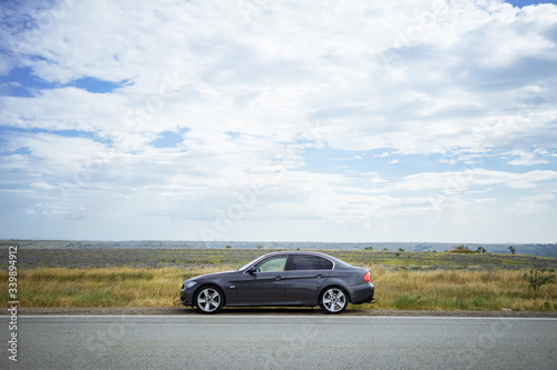 Car on the road on the background of a field © Александр Кудрявцев