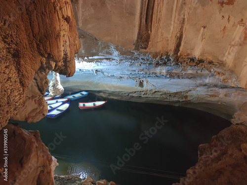 Big rude cave with lake.  Boats on the lake in the cave top view.