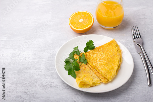 Keto breakfast high-fat low-carb, pancakes without flour and nuts, freshly squeezed orange juice and orange on a light gray background