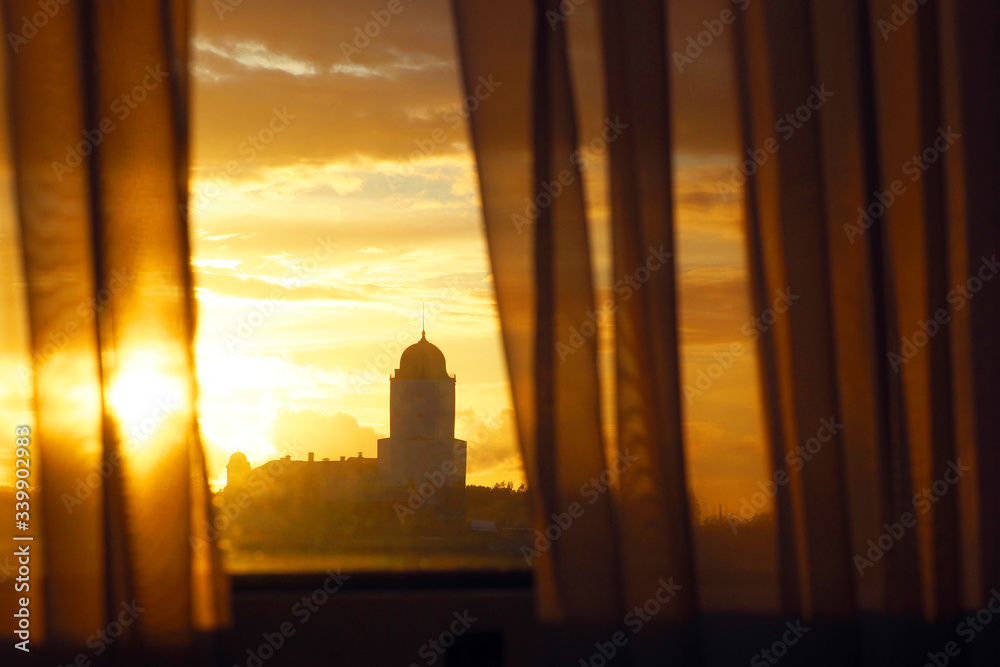 View from the window on Saint Olav tower, medieval Swedish fortress castle on the sunset background in Vyborg, Russia. Rays of the sunset sun, sun glare