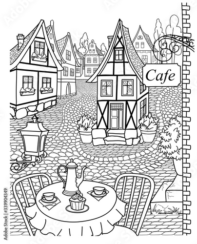 Cozy street with cobblestone pavement, lovely houses and cafe.