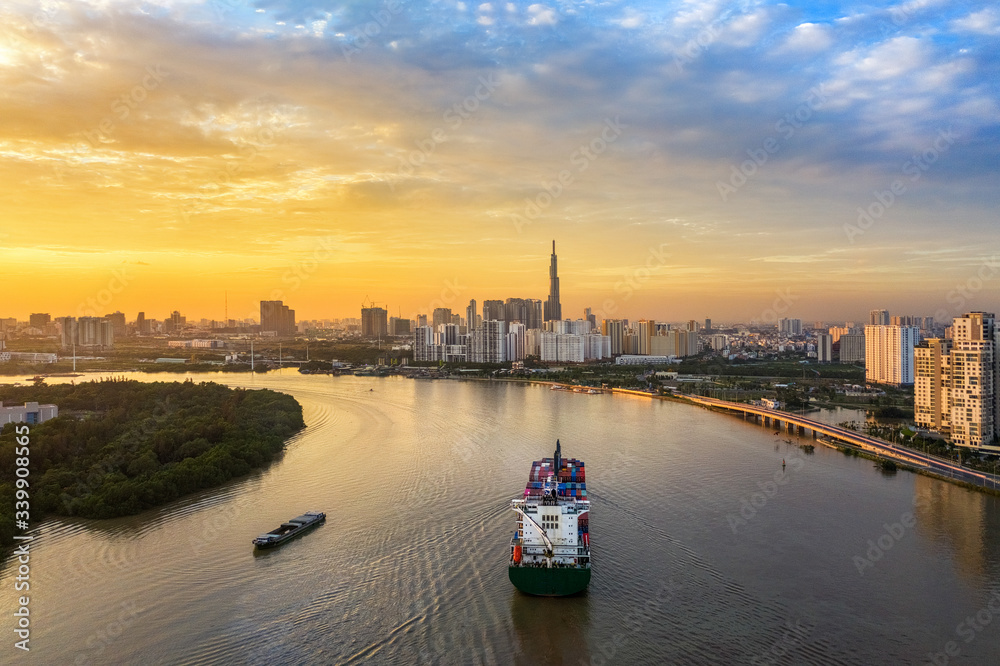 Aerial view of center Ho Chi Minh City, Vietnam with development buildings, transportation, energy power infrastructure. View from the Saigon river  with ships on the river. 