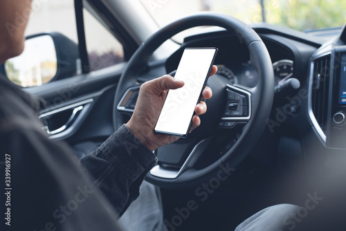 Man using smartphone inside car © tippapatt