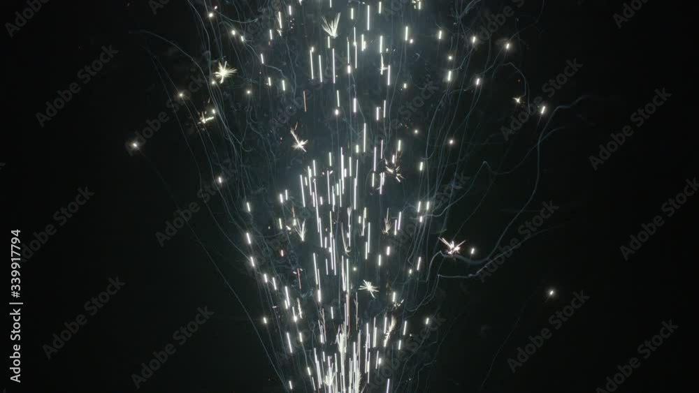 Slow motion shot of fireworks producing an upward shower of sparks against a black background. Commonly known as a gerb, this pyrotechnic is also called a sparkling fountain or waterfall.