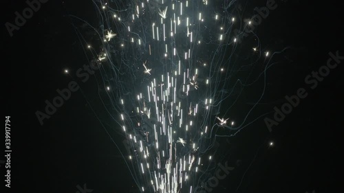 Slow motion shot of fireworks producing an upward shower of sparks against a black background. Commonly known as a gerb, this pyrotechnic is also called a sparkling fountain or waterfall.