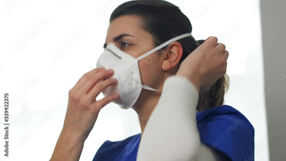 health, medicine and pandemic concept - young female doctor or nurse wearing face protective respirator mask for protection from virus disease