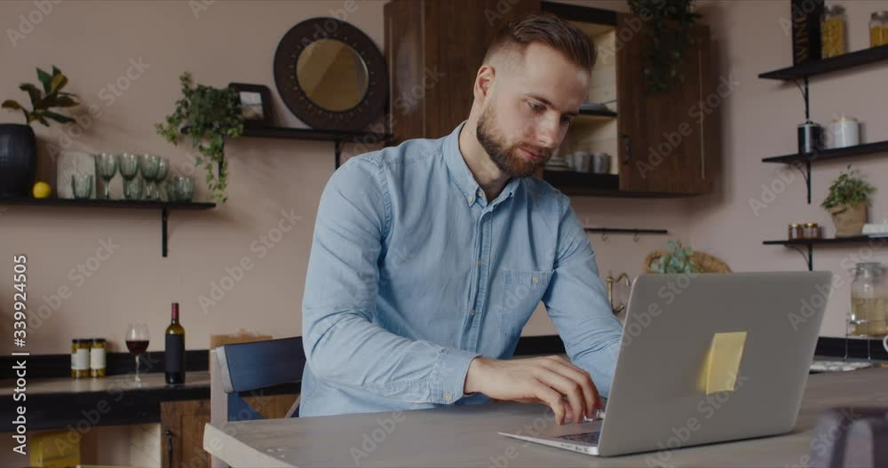 Caucasian male having a conversation during video call with colleagues, kitchen background. Quarantine working, stay home, coronavirus pandemic. Caucasian male having a conversation during video call with colleagues, kitchen background. Quarantine working, stay home, coronavirus pandemic.