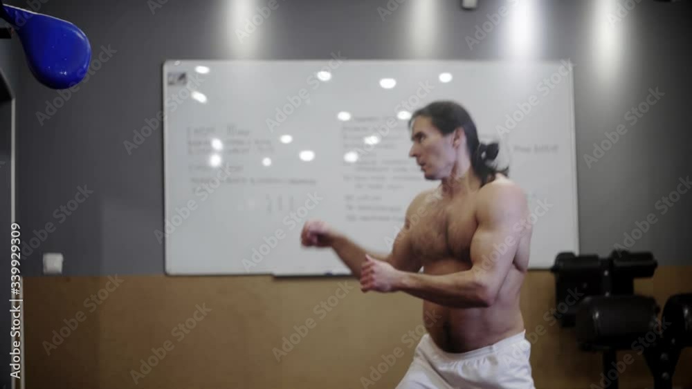 Athletic guy with a sports torso and long hair, trains, taekwondo kicks
