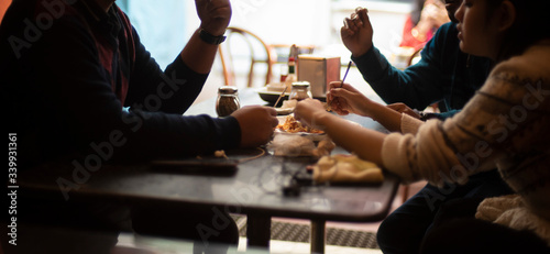 Silhouette of a group of young friends having lunch in a restaurant in a festive day. Indian lifestyle.